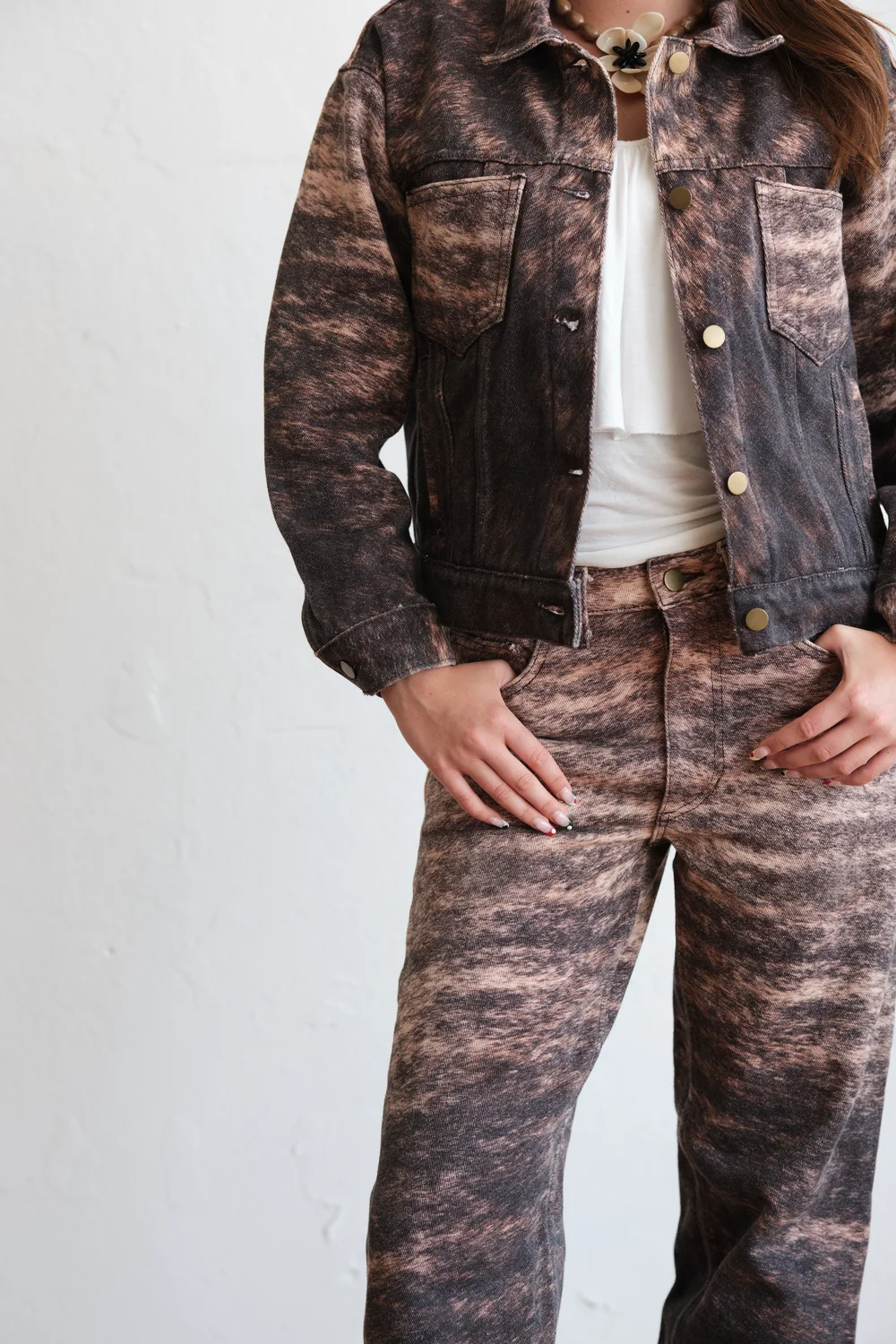 A model in a WTRLSS marbled denim jacket and pant — an impossible finish, worn